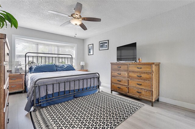 8 Hathaway Ln, Wilton Manors, FL 33305 - bedroom with wood finished floors, a textured ceiling, baseboards, and ceiling fan