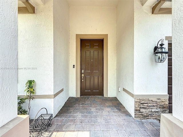 doorway to property featuring stucco siding