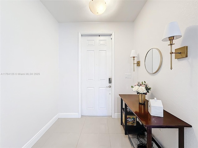 doorway featuring baseboards and light tile patterned flooring