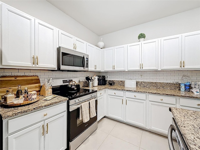 kitchen featuring stainless steel appliances, light stone countertops, white cabinetry, and backsplash