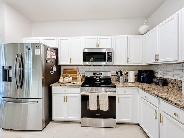 kitchen with tasteful backsplash, white cabinets, and appliances with stainless steel finishes