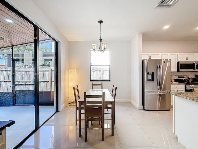dining space featuring visible vents, a notable chandelier, plenty of natural light, and light tile patterned floors