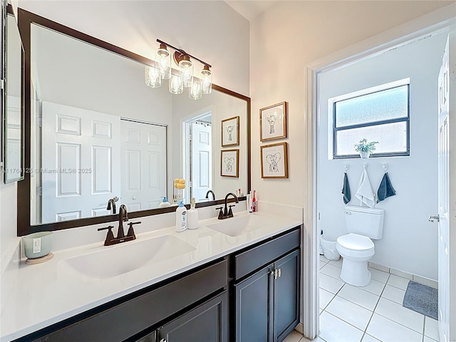 bathroom with toilet, tile patterned floors, double vanity, and a sink