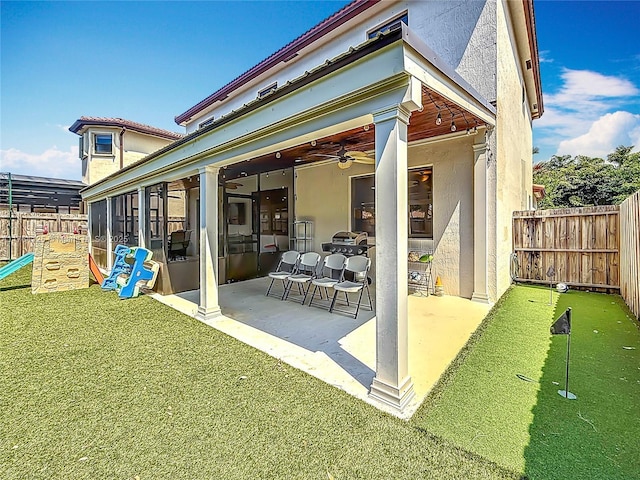 rear view of property featuring a fenced backyard, a ceiling fan, a patio, and stucco siding