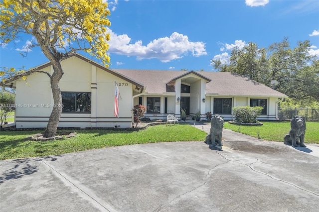 view of front of house with stucco siding, fence, and a front lawn