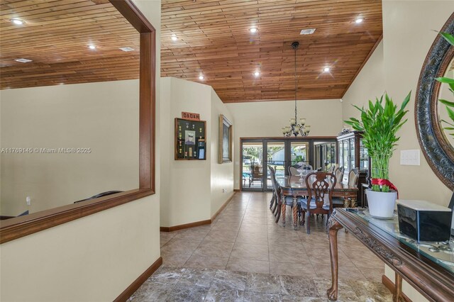 hallway with high vaulted ceiling, wooden ceiling, a chandelier, baseboards, and recessed lighting