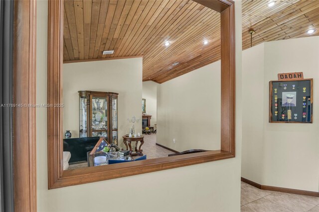 hallway with baseboards, lofted ceiling, tile patterned flooring, and wood ceiling