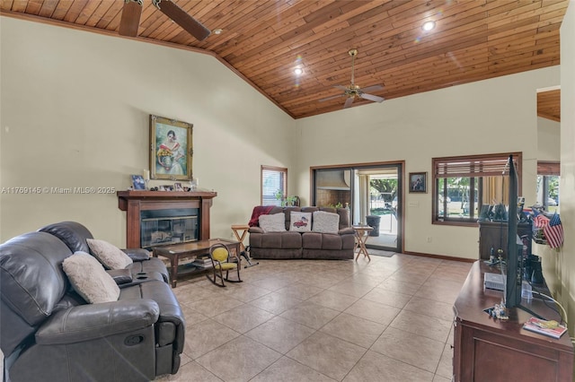 living room featuring light tile patterned flooring, high vaulted ceiling, wooden ceiling, a glass covered fireplace, and ceiling fan