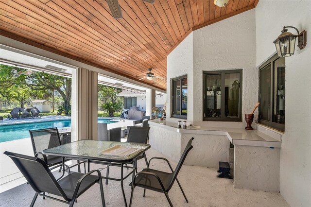 view of patio featuring outdoor dining space, an outdoor pool, and ceiling fan