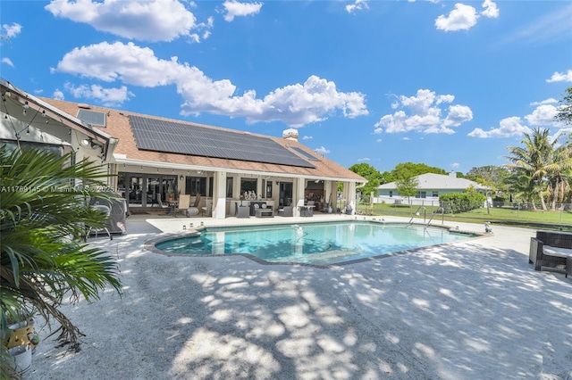 pool with an outdoor hangout area, fence, and a patio area