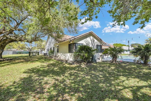 view of property exterior featuring a lawn and fence
