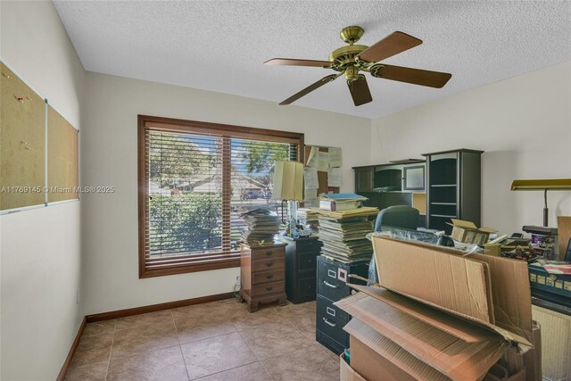 home office with tile patterned flooring, a textured ceiling, baseboards, and ceiling fan