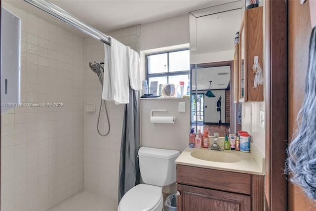bathroom featuring toilet, vanity, and a tile shower