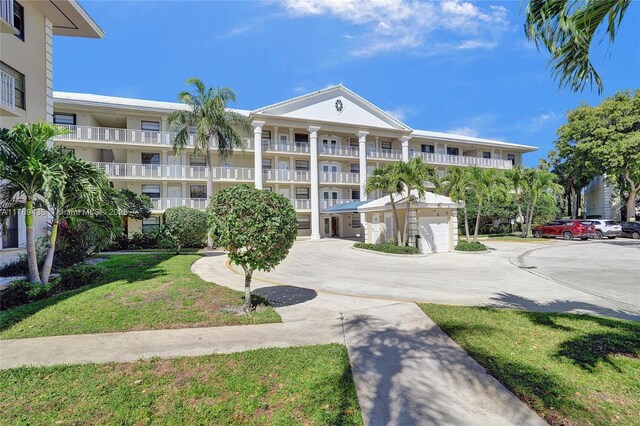 3515 Village Blvd Unit 105, West Palm Beach, FL 33409 - view of building exterior with curved driveway and an attached garage