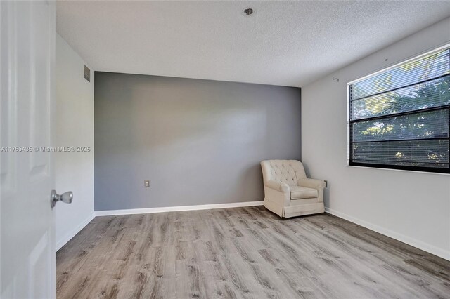 3515 Village Blvd Unit 105, West Palm Beach, FL 33409 - unfurnished room featuring a textured ceiling, baseboards, wood finished floors, and visible vents