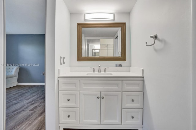 bathroom with vanity, baseboards, and wood finished floors