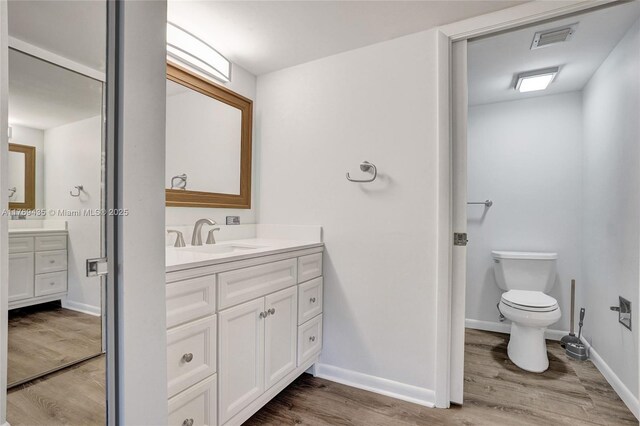 3515 Village Blvd Unit 105, West Palm Beach, FL 33409 - full bath featuring baseboards, visible vents, wood finished floors, and vanity