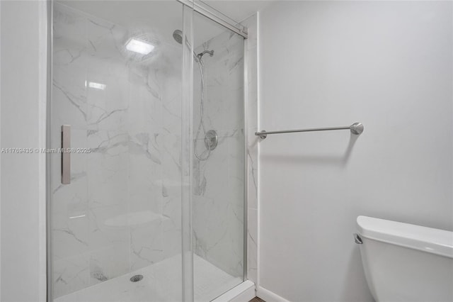full bath with a marble finish shower and toilet