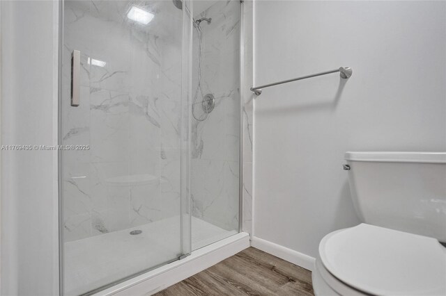 3515 Village Blvd Unit 105, West Palm Beach, FL 33409 - bathroom with toilet, baseboards, a marble finish shower, and wood finished floors