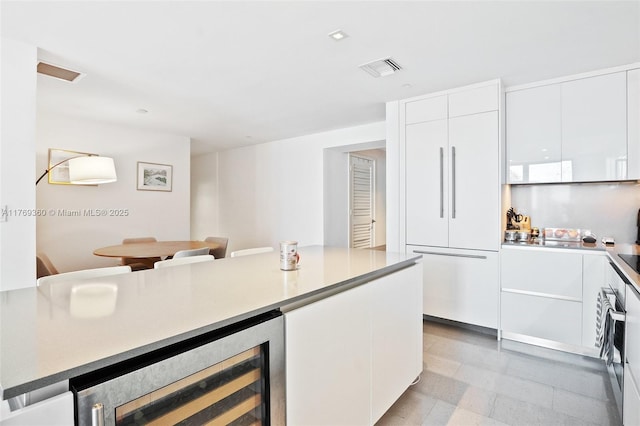 68 SE 6th St Unit 805, Miami, FL 33131 - kitchen with visible vents, oven, modern cabinets, white cabinetry, and beverage cooler