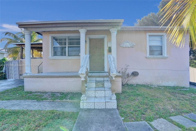731 SW 8th Ave, Hallandale Beach, FL 33009 - view of front of home featuring fence, a front yard, stucco siding, and a porch