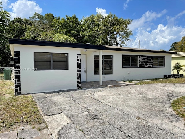 view of front of house featuring stucco siding and a front lawn