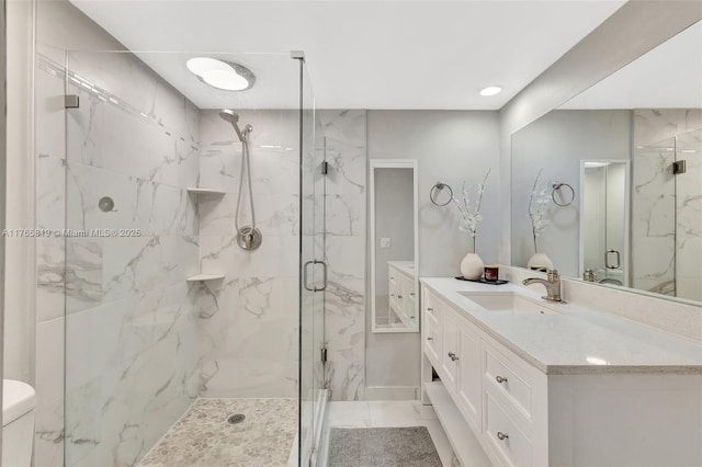 full bath featuring a marble finish shower, marble finish floor, and vanity