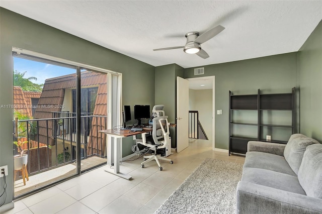 home office with ceiling fan, tile patterned floors, visible vents, baseboards, and a textured ceiling