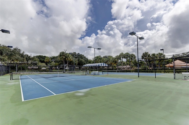 view of tennis court with fence and community basketball court