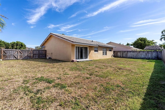 14930 SW 178th Ter, Miami, FL 33187 - rear view of property featuring stucco siding, a lawn, and a fenced backyard