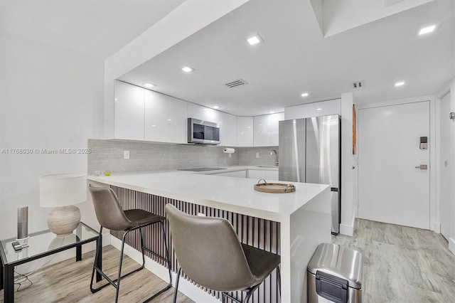 14601 N Kendall Dr Unit 206K, Miami, FL 33186 - kitchen with visible vents, a peninsula, modern cabinets, appliances with stainless steel finishes, and white cabinetry