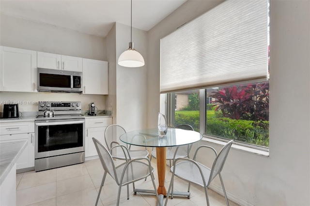 16103 Opal Creek Dr, Weston, FL 33331 - kitchen with stainless steel appliances, white cabinetry, light countertops, and hanging light fixtures