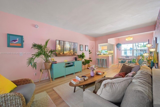 living area with baseboards and wood finished floors