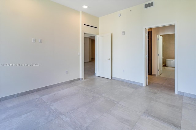 empty room with a towering ceiling, baseboards, and visible vents