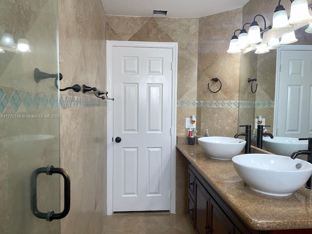 full bathroom featuring tile walls, double vanity, a sink, and tile patterned flooring