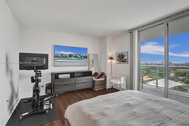 bedroom featuring baseboards, floor to ceiling windows, wood finished floors, and access to outside