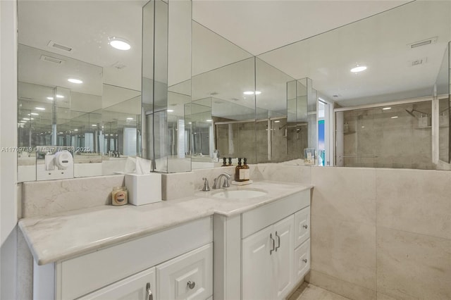 bathroom featuring vanity, a tile shower, and visible vents