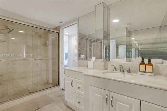 full bathroom with tile patterned flooring, vanity, visible vents, and a shower stall