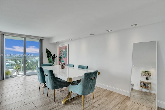 dining area with baseboards, expansive windows, and wood tiled floor
