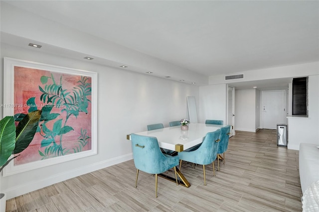 dining area featuring baseboards, light wood-style flooring, and visible vents