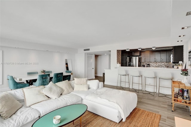 living area featuring visible vents and light wood finished floors