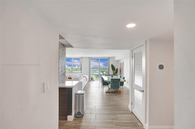 corridor with baseboards and wood tiled floor