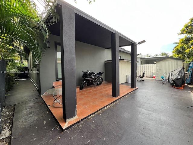 view of patio / terrace featuring fence, an outdoor structure, and a storage shed