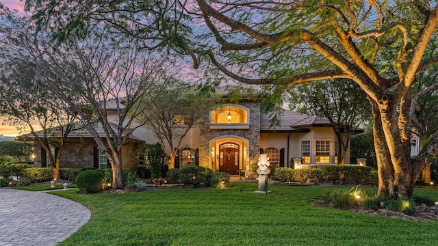 12483 Grand Oaks Dr, Davie, FL 33330 - view of front of property with stone siding, stucco siding, and a yard