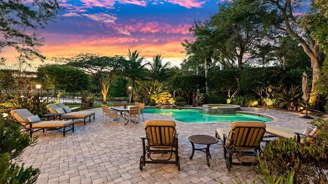 12483 Grand Oaks Dr, Davie, FL 33330 - pool at dusk with a patio area and a pool with connected hot tub