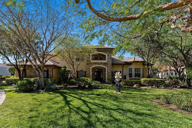 12483 Grand Oaks Dr, Davie, FL 33330 - mediterranean / spanish home featuring stucco siding, stone siding, and a front lawn