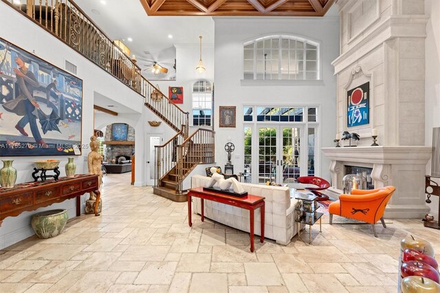 12483 Grand Oaks Dr, Davie, FL 33330 - living room with a fireplace, stone tile floors, a towering ceiling, french doors, and stairs