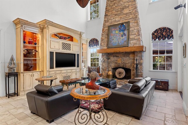 12483 Grand Oaks Dr, Davie, FL 33330 - living area with a towering ceiling, stone tile flooring, a stone fireplace, and baseboards