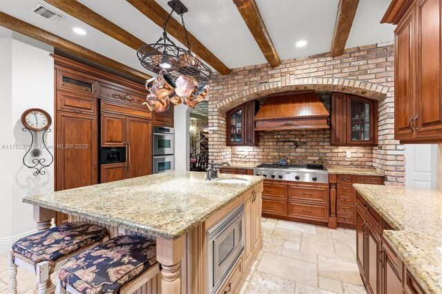 12483 Grand Oaks Dr, Davie, FL 33330 - kitchen with appliances with stainless steel finishes, custom exhaust hood, a sink, light stone countertops, and glass insert cabinets