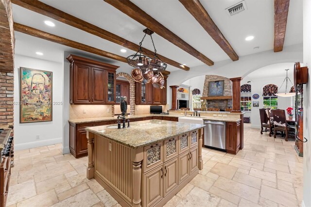 12483 Grand Oaks Dr, Davie, FL 33330 - kitchen featuring ornate columns, dishwasher, arched walkways, a center island with sink, and stone tile floors